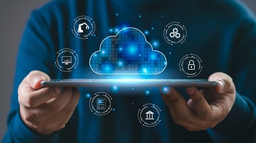 Person holding a tablet with floating icons around a digital cloud, representing various cloud services