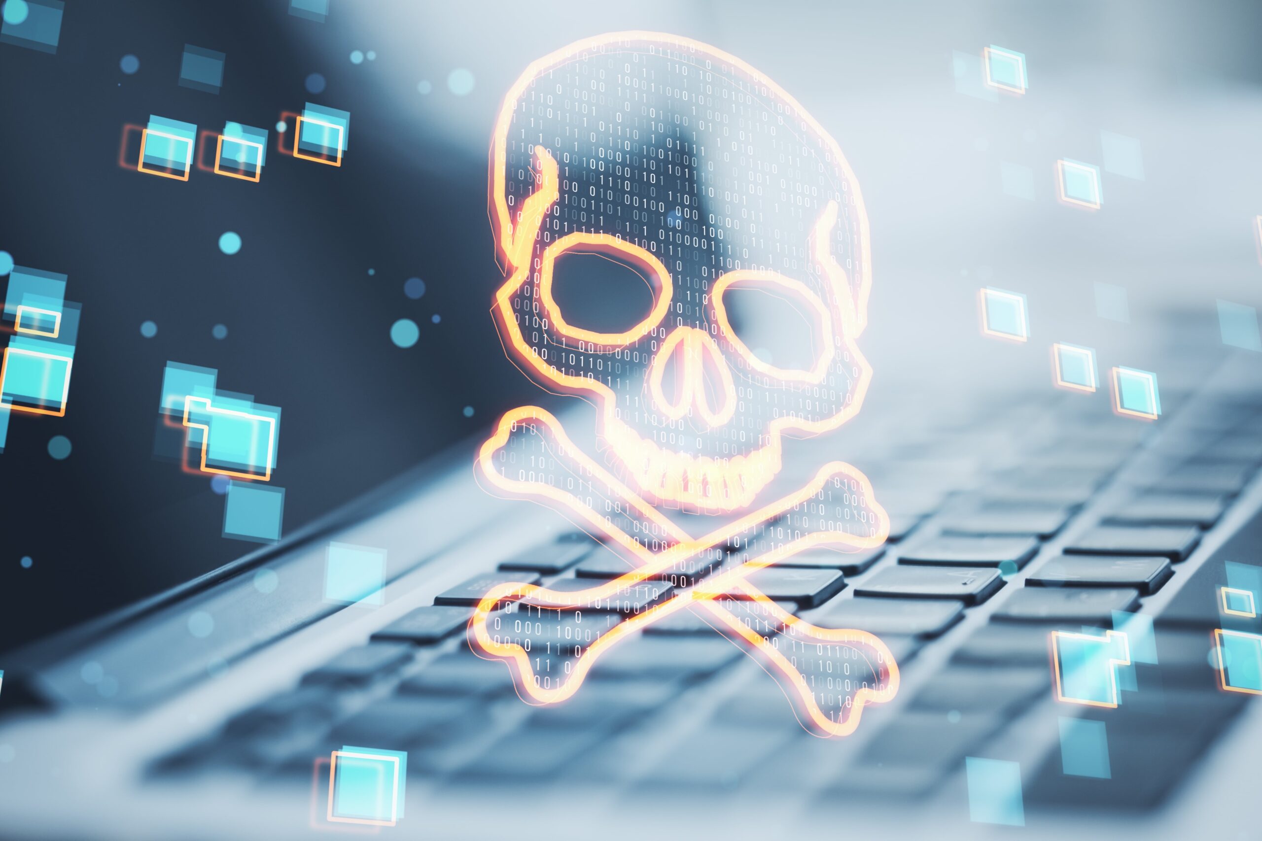 Digital skull and crossbones symbol hovering over a laptop keyboard, representing cybersecurity threats or malware attacks.