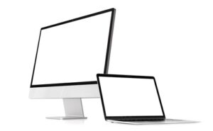 Desktop computer and laptop with blank screens on white background