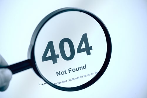 Magnifying glass focusing on a 404 Not Found error message on a computer screen