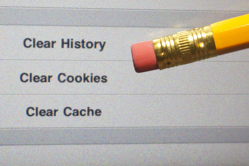 Close-up of a pencil eraser pointing at options to clear history, cookies, and cache on a digital screen