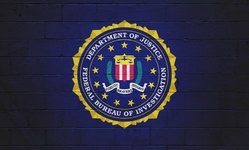 FBI seal painted on a dark brick wall with blue and gold colors