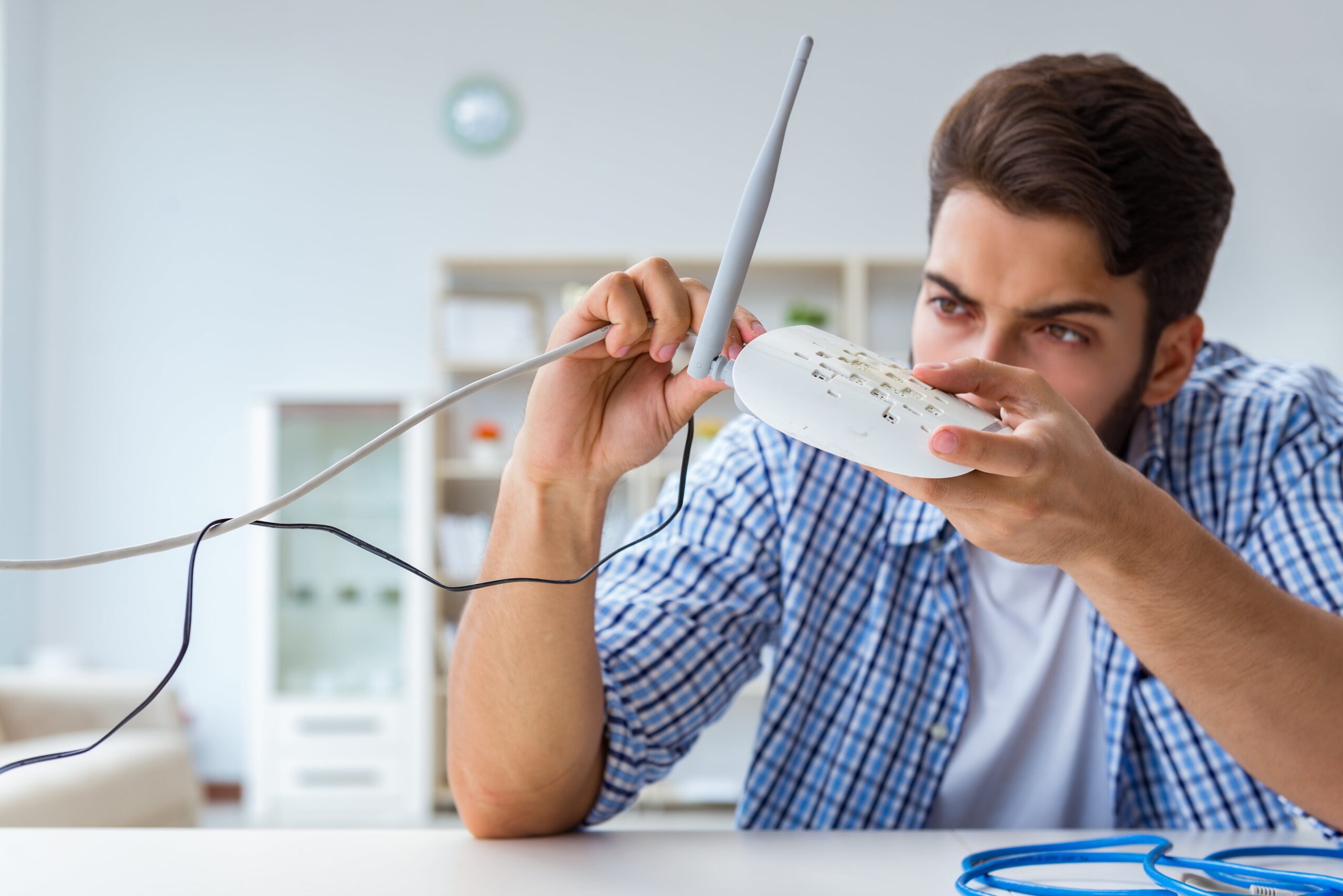 Man trying to fix a Wi-Fi router while troubleshooting an internet connection at home
