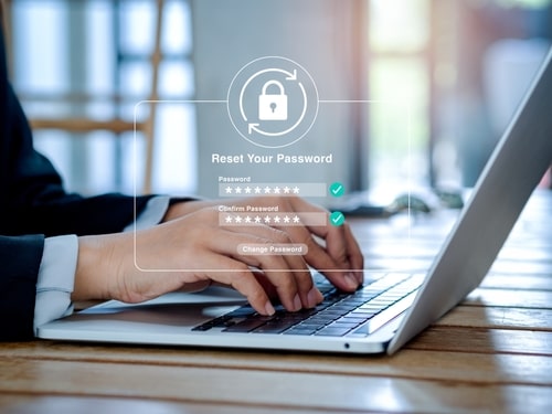 Person typing on a laptop with a virtual interface showing a "Reset Your Password" screen