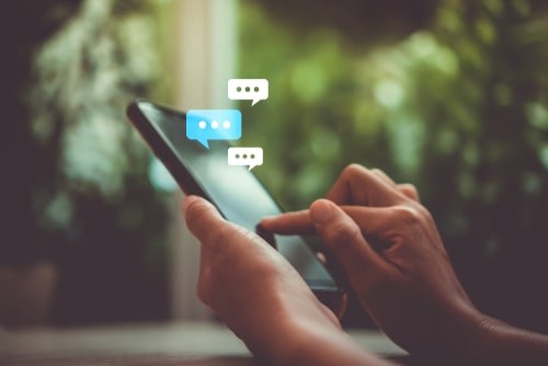 Person messaging on smartphone with chat bubbles, representing online communication safety