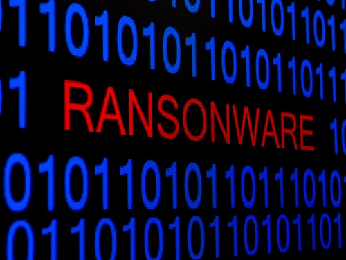 Ransomware text in red among binary code representing a cyberattack or malware threat