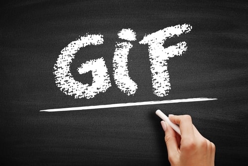 Hand writing the word GIF in chalk on a blackboard, symbolizing digital image format
