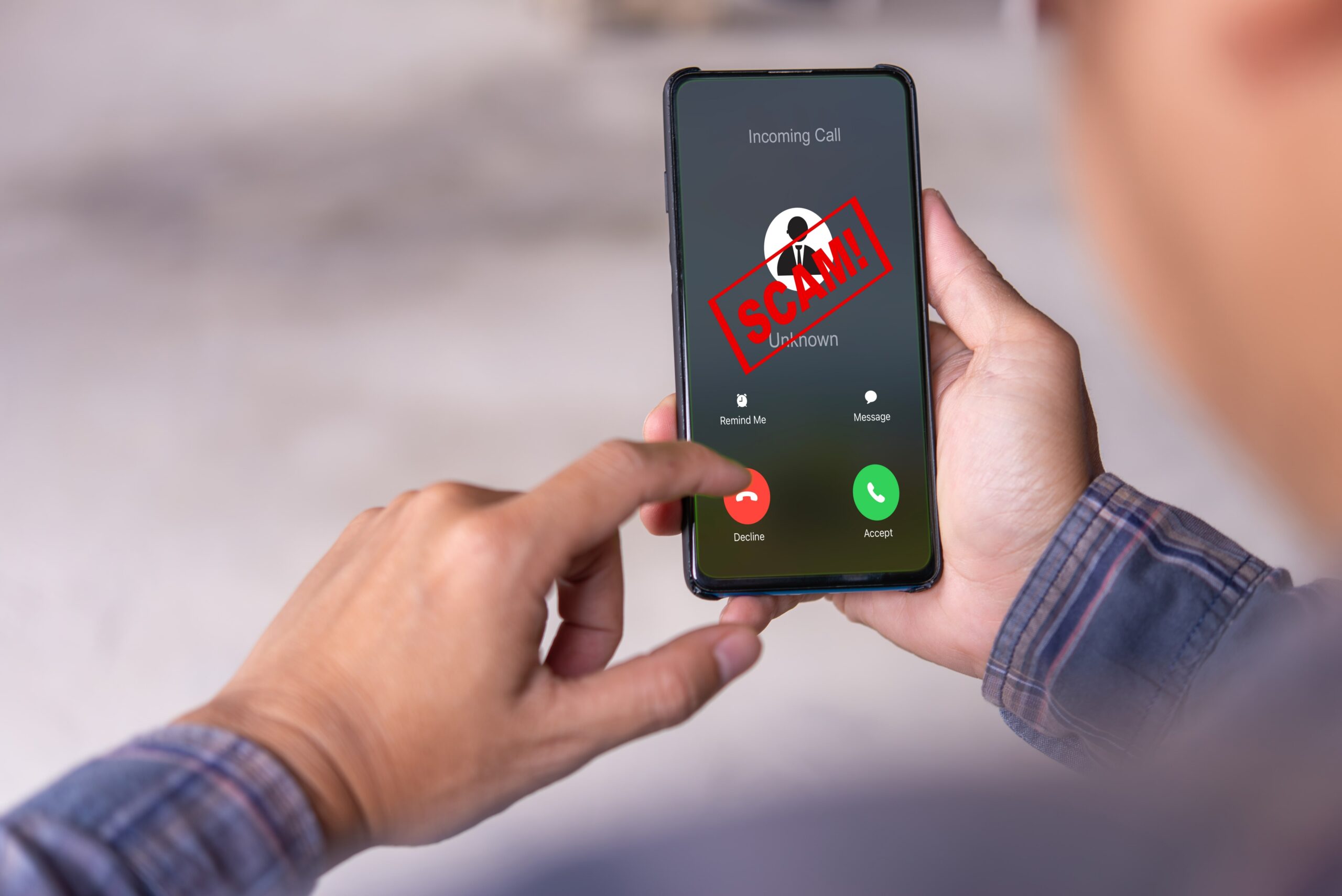 Person holding smartphone with incoming scam call alert from unknown number
