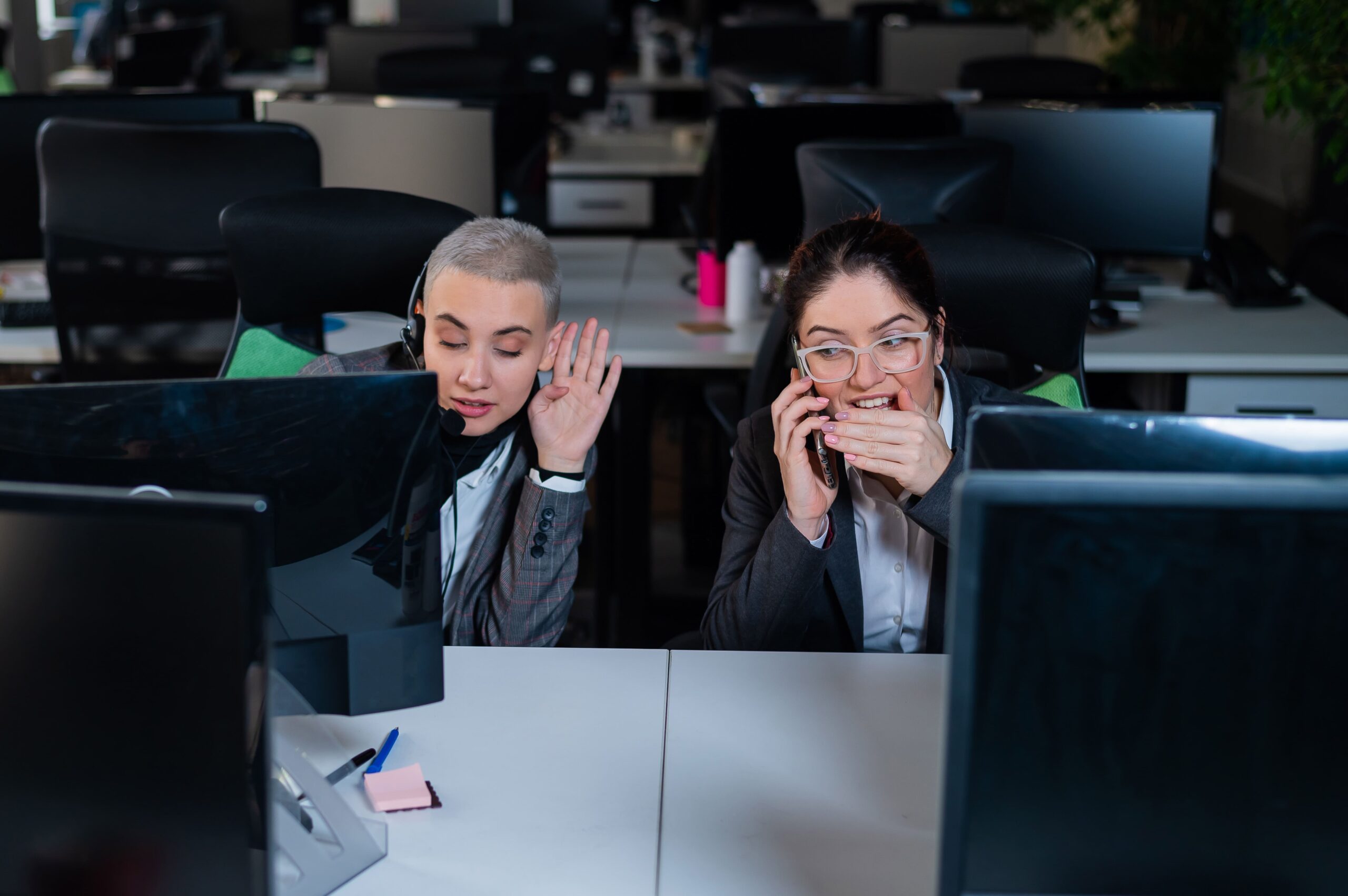 Call center employee overhearing a customer conversation through coworker's headset