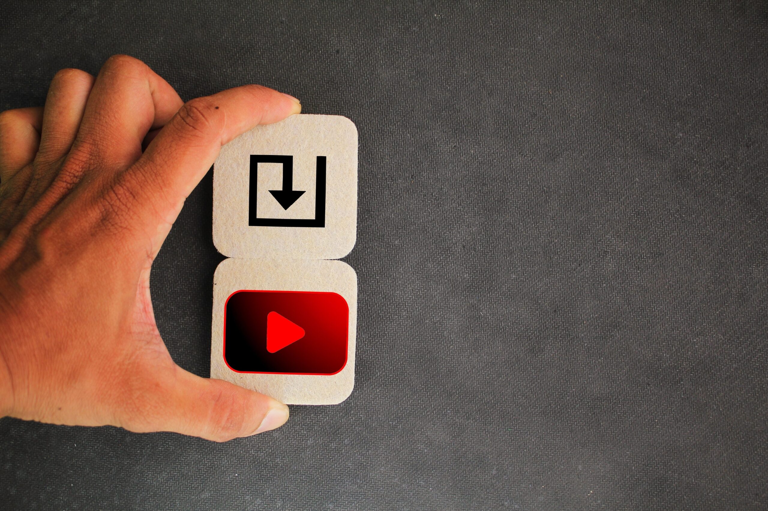 Hand holding tiles with download and video play icons, representing video download concept