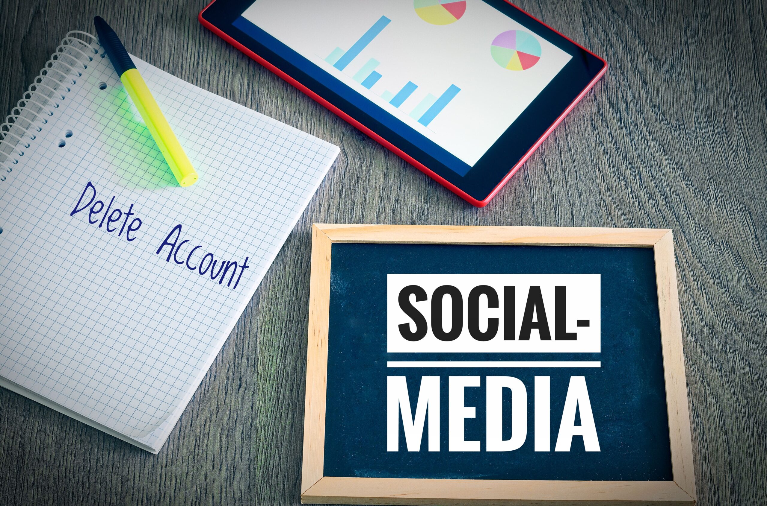 Notebook with 'Delete Account' next to chalkboard labeled 'Social Media' and digital tablet