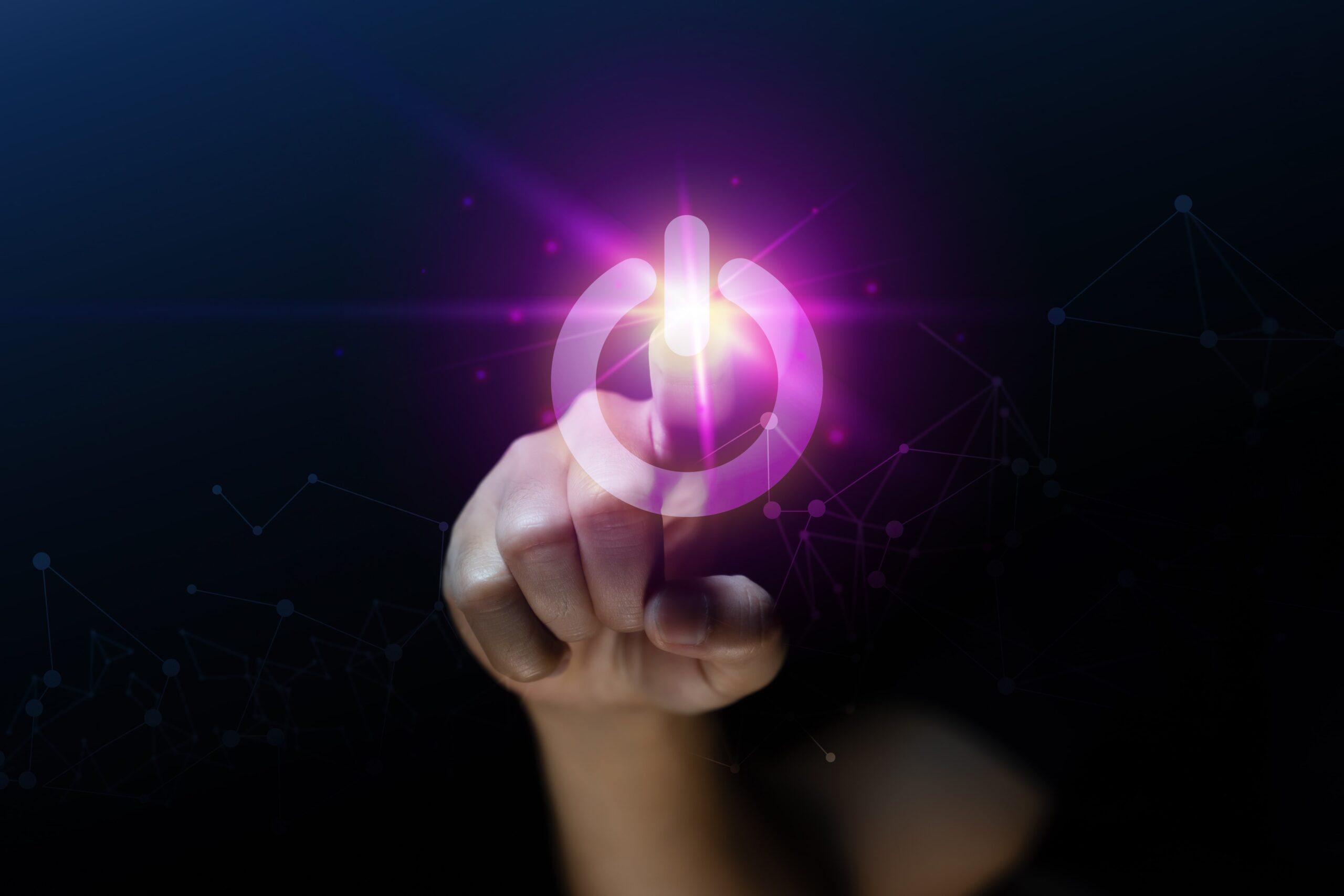 Hand pressing virtual power button with glowing digital interface.