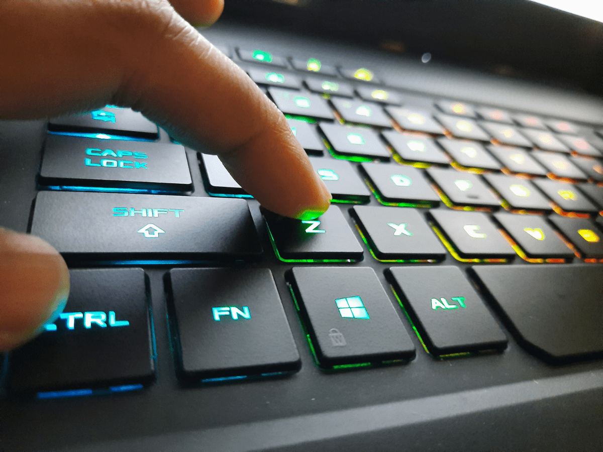 Closeup of finger pressing key on keyboard.