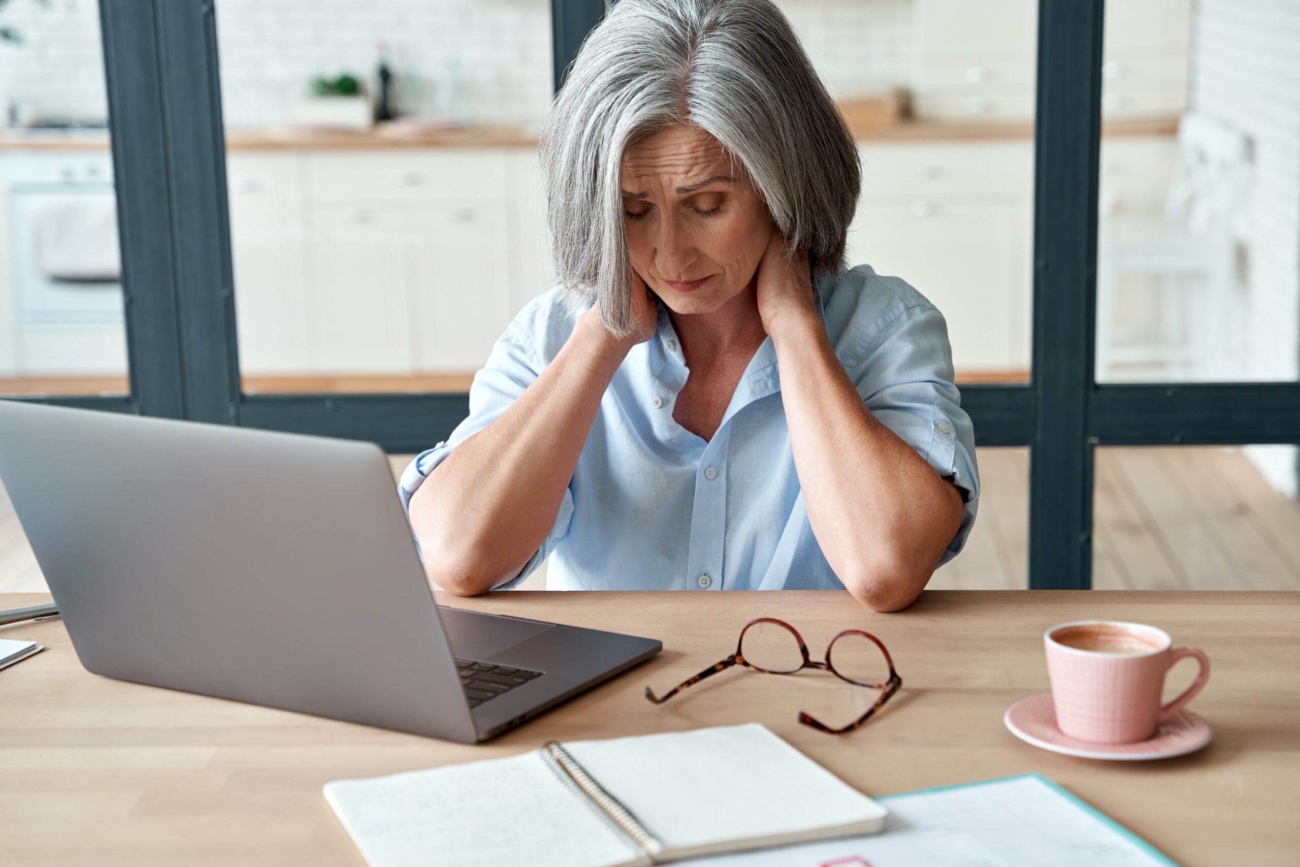 A lady looking upset and frustrated at her MacBook computer