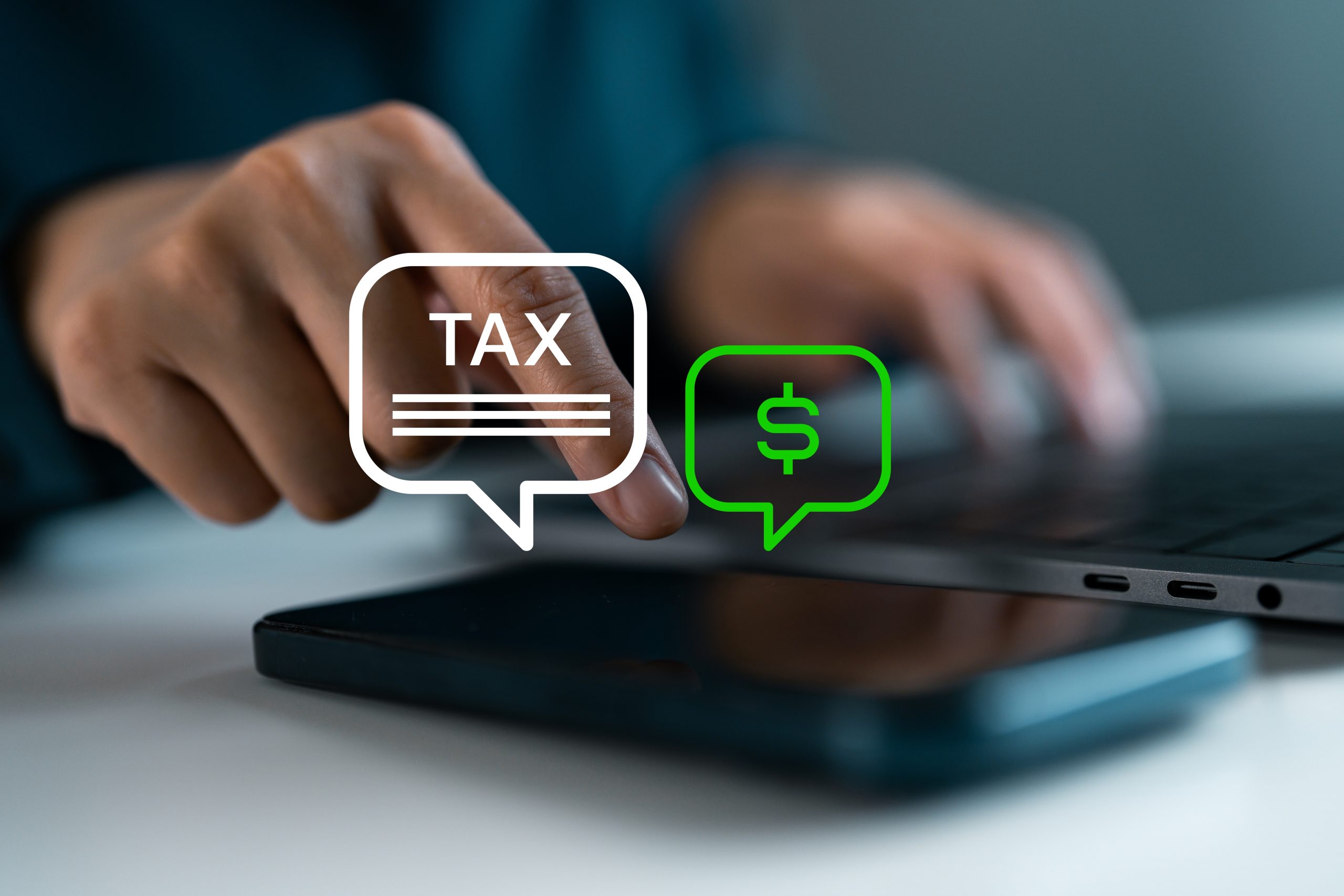 Close-up of a person using a tablet with tax and dollar sign icons overlaid on the screen.