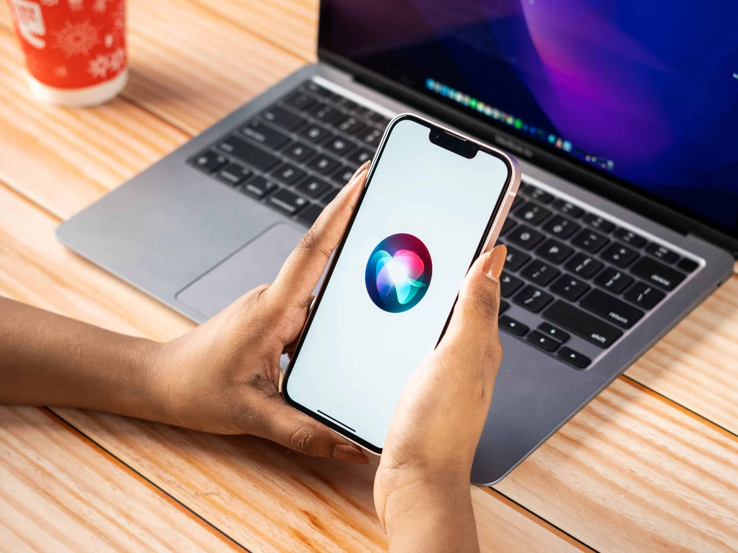 Hands holding iPhone with voice assist.