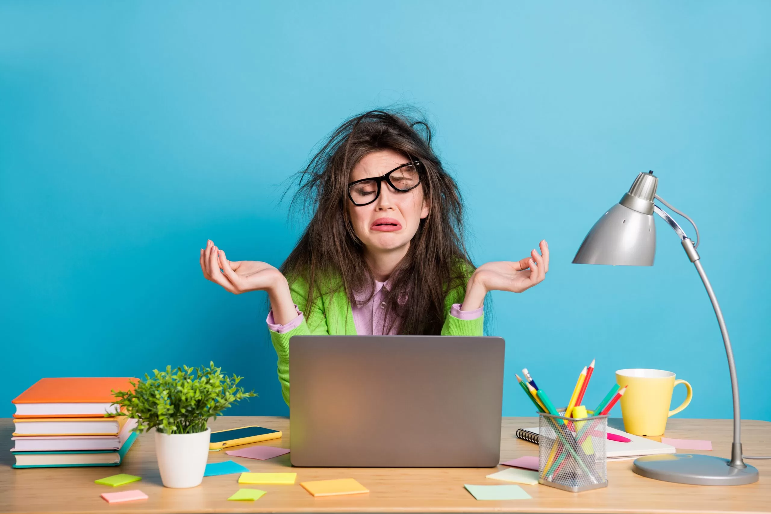A Frustrated woman in front of a computer that will not turn on.